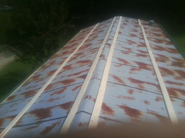 Rusted metal roof panels with new wood purlins before replacement — Storm Damage Roof Repair in South Easton by Roofing Brothers
