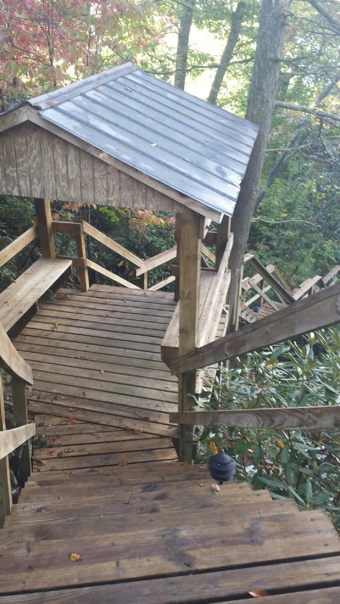 Metal roofed shelter over wooden steps on a wooded walkway — Skylight Repair & Installation work by our crew in South Easton