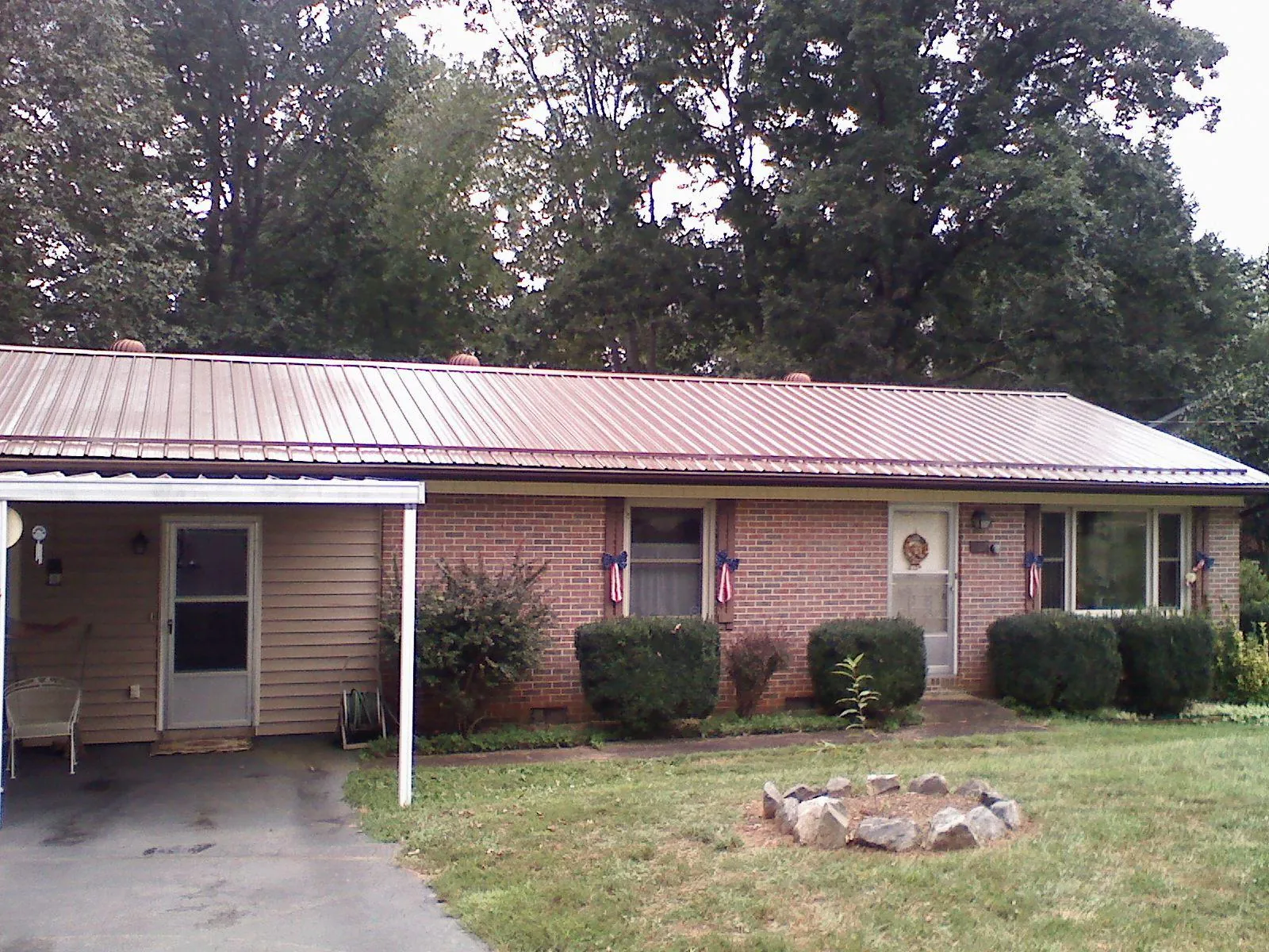 Bronze metal roof and carport on a brick ranch home — Roof Repair work by our crew in South Easton